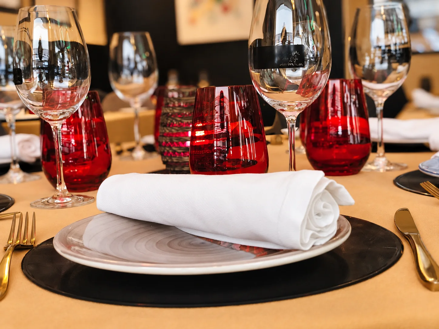 Mesa preparada con copas, vajilla y servilleta blanca